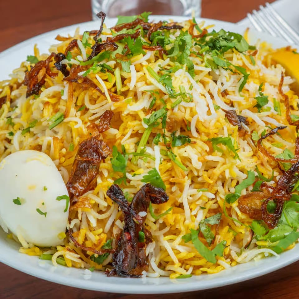 Biryani Bowl's Indian biryani with rice, fried onions, cilantro, and a hard-boiled egg.